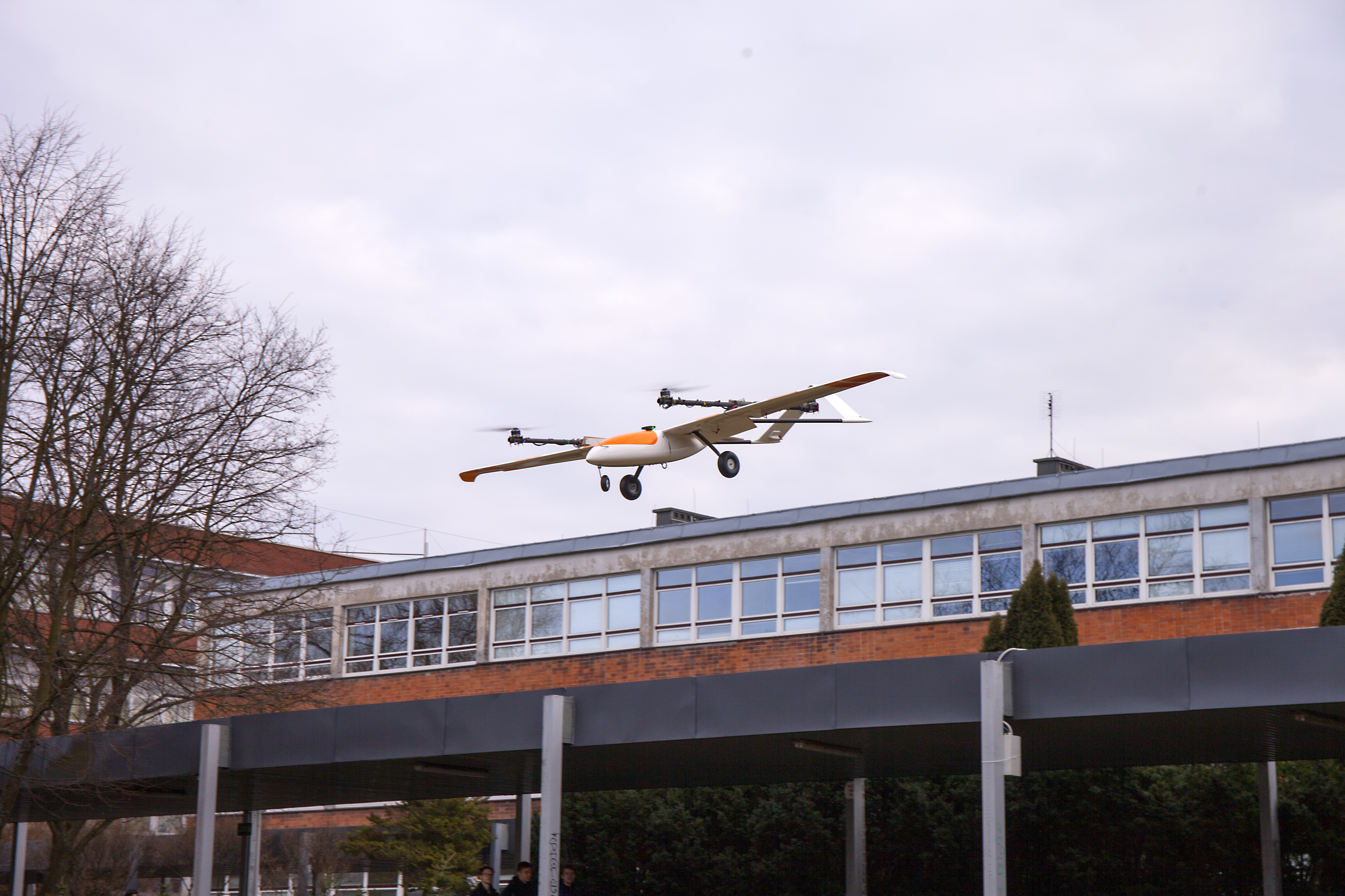 Testy elementów systemu AVAL przeprowadzone na Politechnice Białostockiej. Na zdjęciu dron przelatuje bardzo nisko nad gmachem uczelni