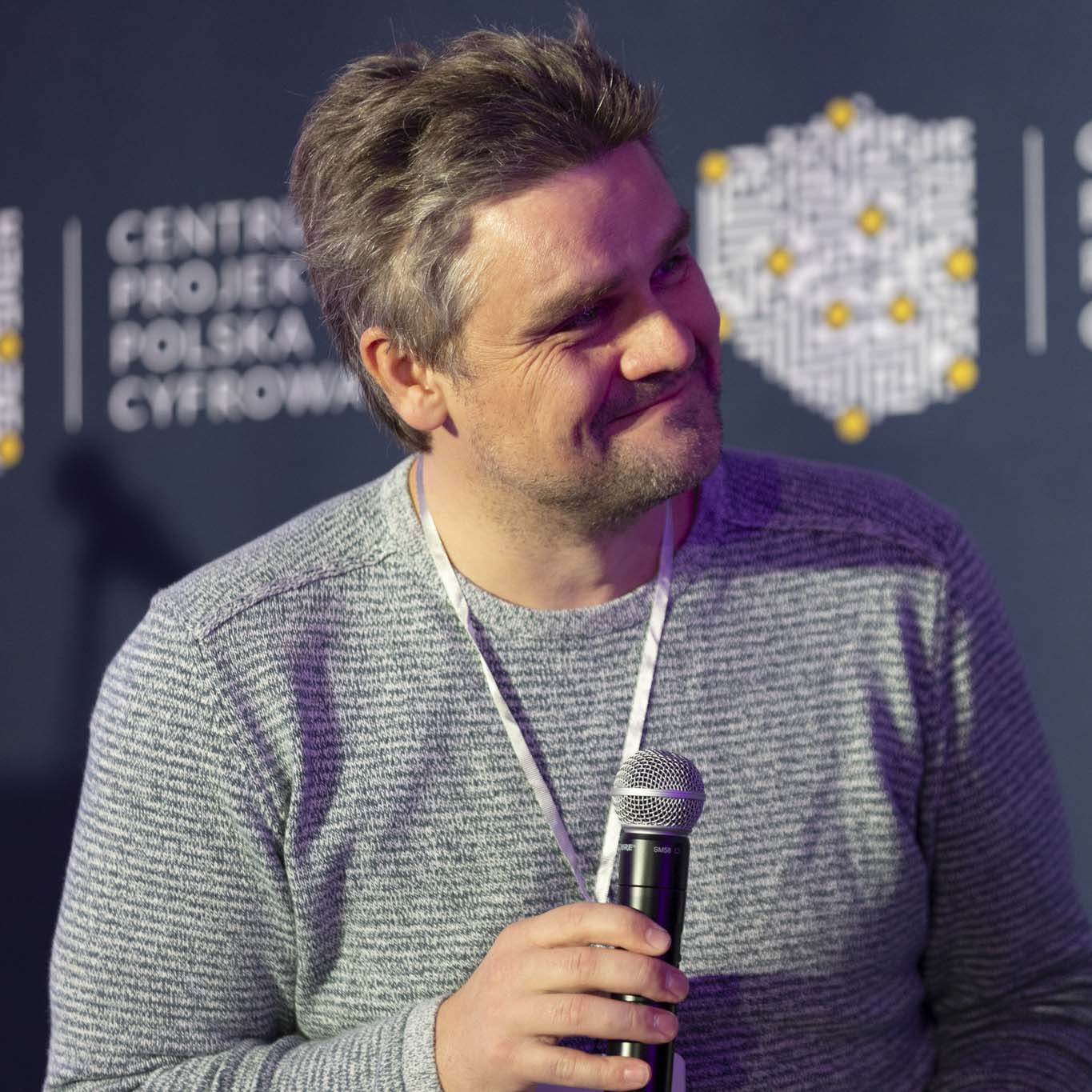 Doktor Iwo Zmyślony patrzy w lewą stronę. Uśmiecha się.