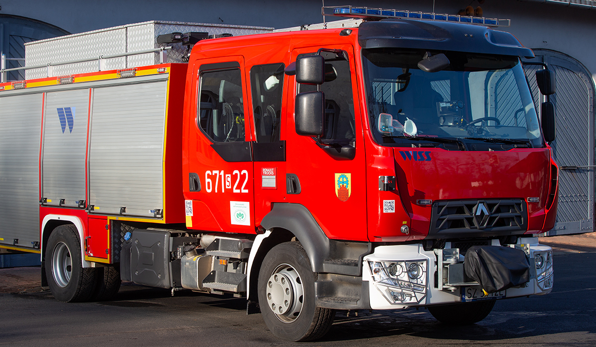 Zdjęcie przedstawia samochód ratowniczo-gaśniczy proszkowy - średni Renault Midlum na tle budynku Komendy Miejskiej Państwowej Straży Pożarnej w Zabrzu
