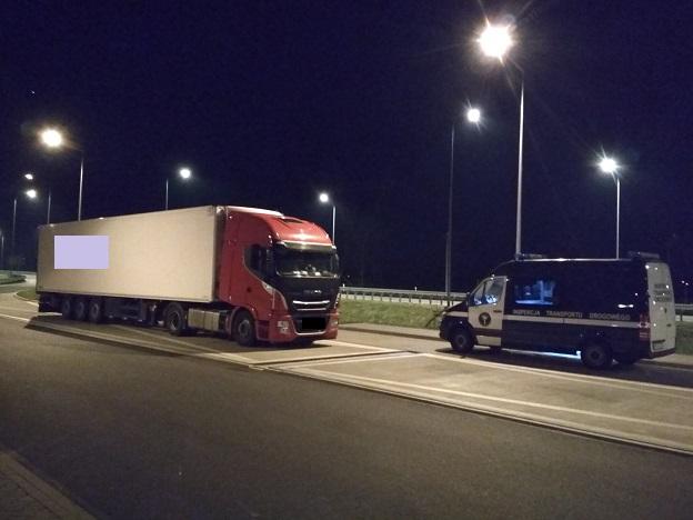 Radiowóz i ciężarówka z czerwoną kabiną i białą naczepą