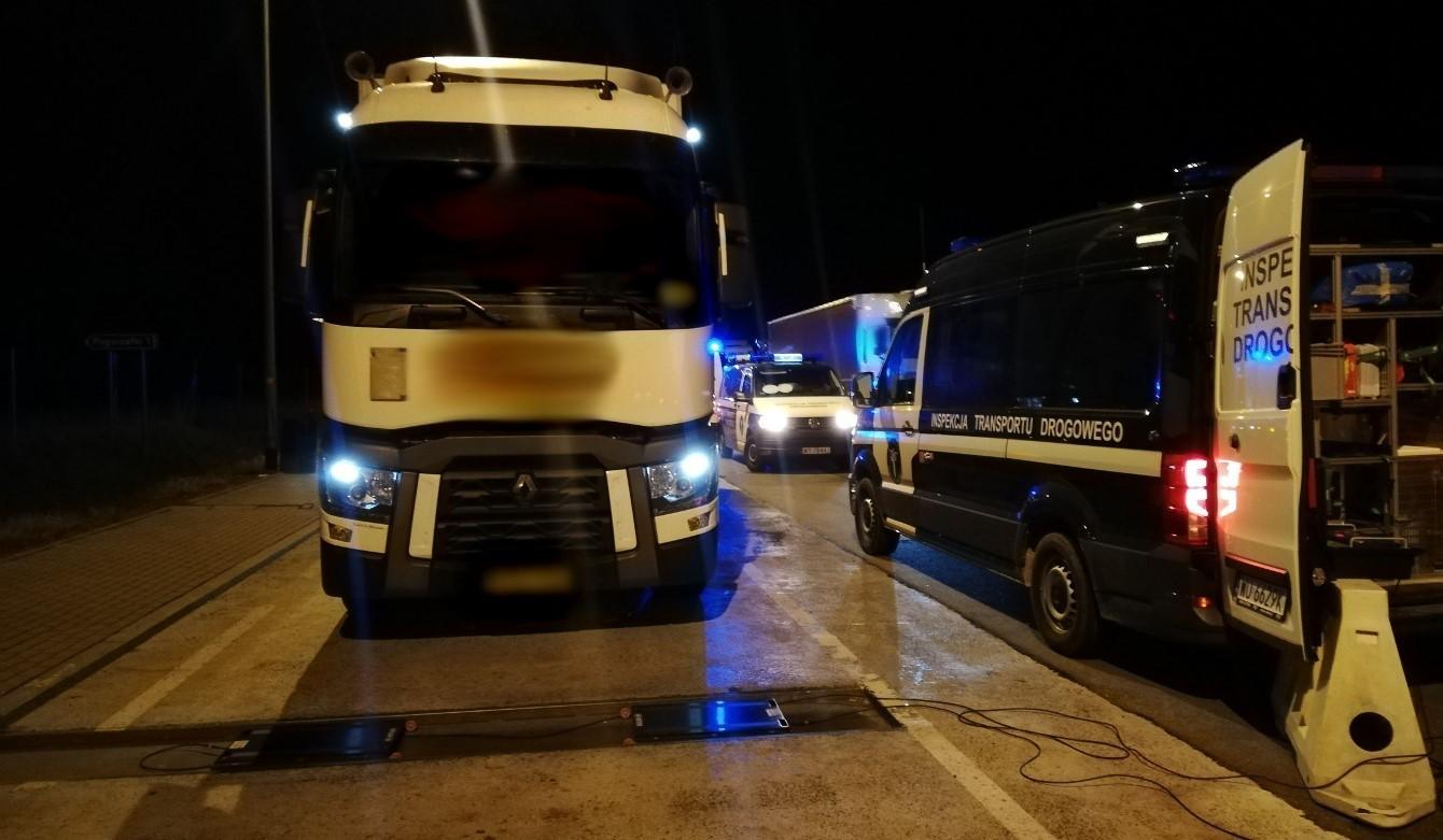 Zatrzymana do kontroli ciężarówka czeka na wjazd na inspekcyjne wagi, a po prawej stronie stoi radiowóz ITD.