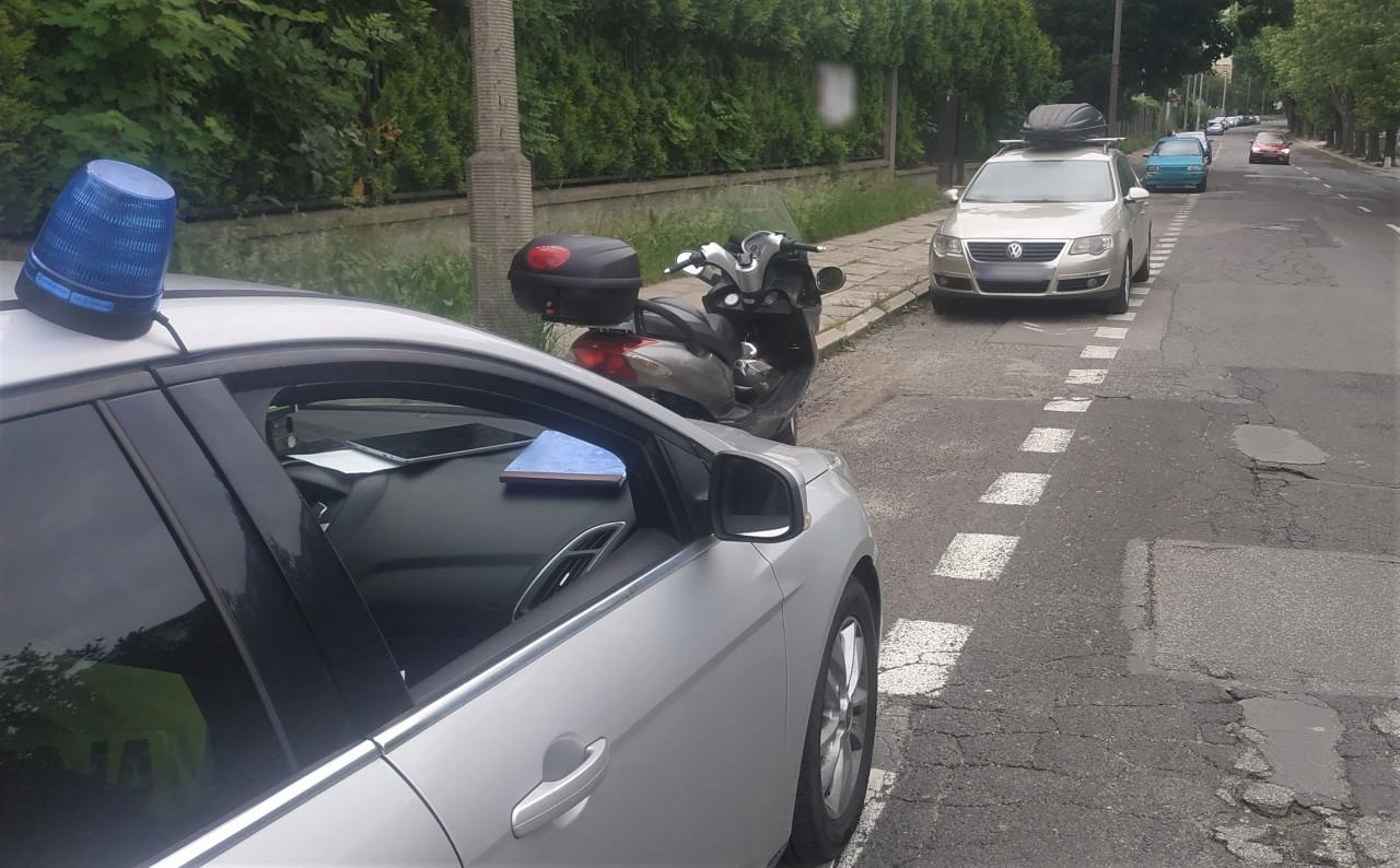 Nieoznakowany radiowóz ITD i stojący przed nim skuter.