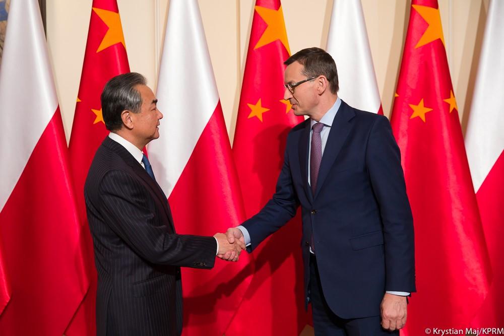 Premier Mateusz Morawiecki ściska dłoń ministrowi spraw zagranicznych Wangowi Yi.