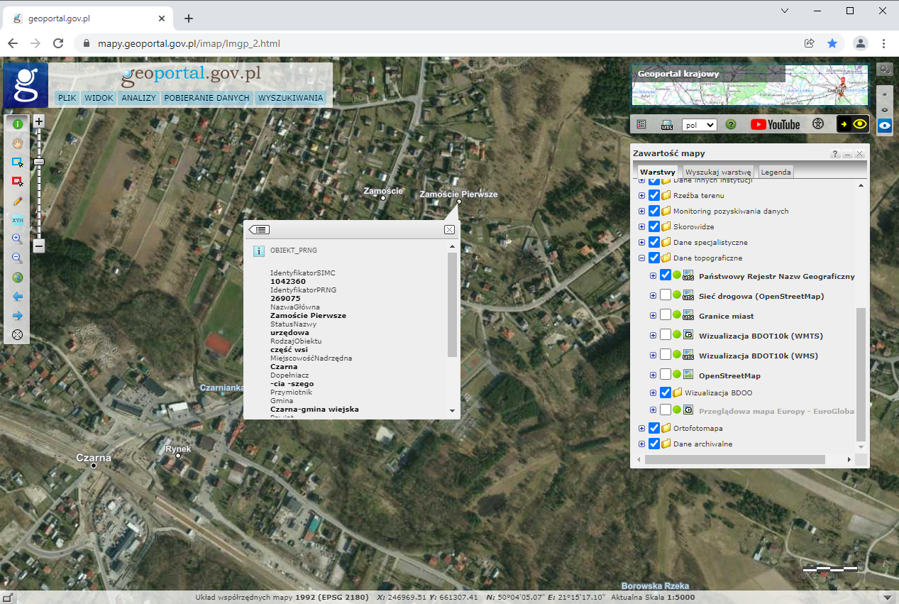 Ilustracja przedstawiająca zrzut ekranu z serwisu www.geoportal.gov.pl z zaznaczoną na podkładzie ortofotomapy lokalizacją miejscowości o urzędowej nazwie Zamoście Pierwsze, część wsi Czarna wraz oknem atrybutów.