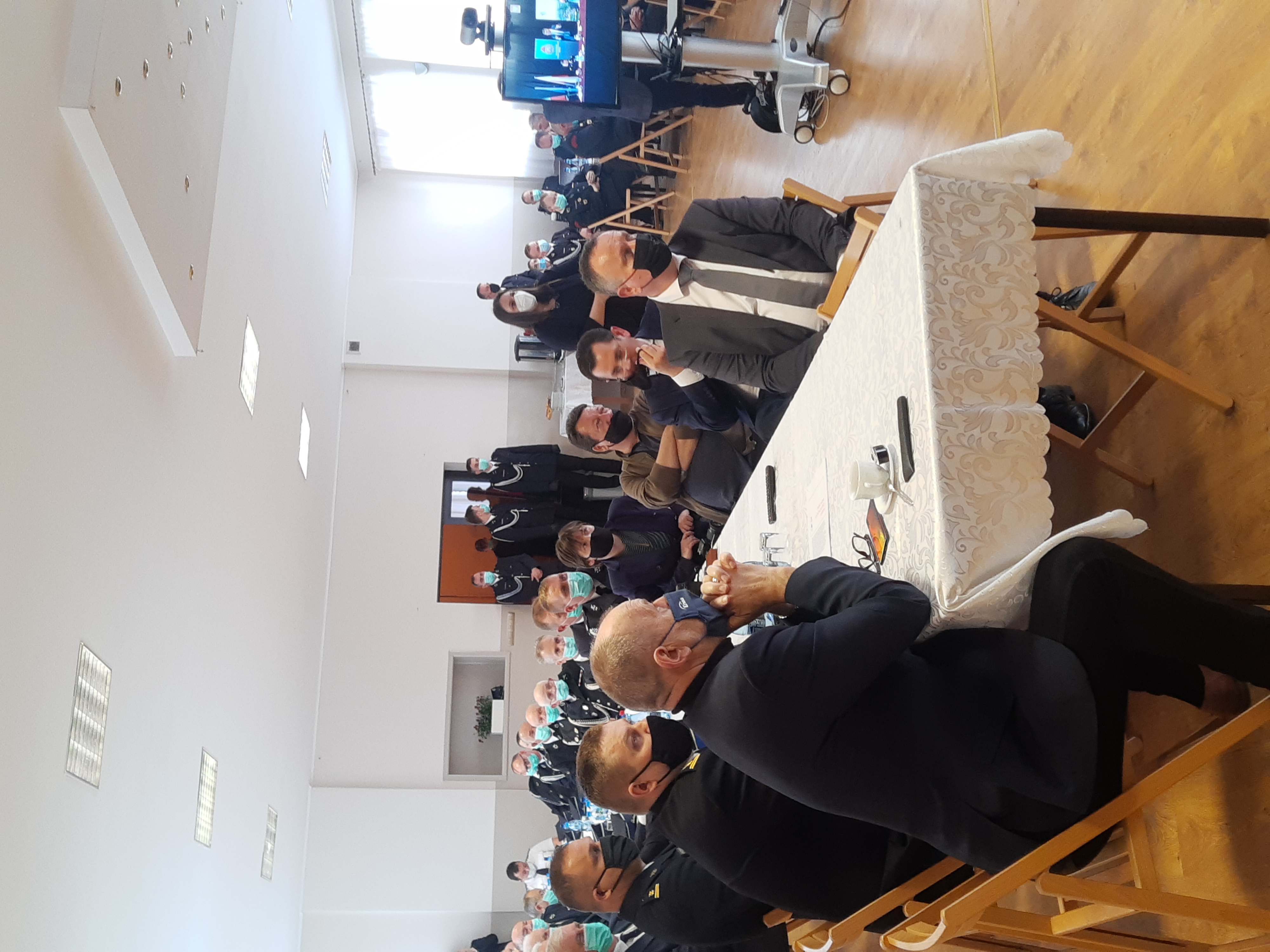 Druhowie OSP siedzący przy stolikach podczas konsultacji społecznych projektu ustawy.