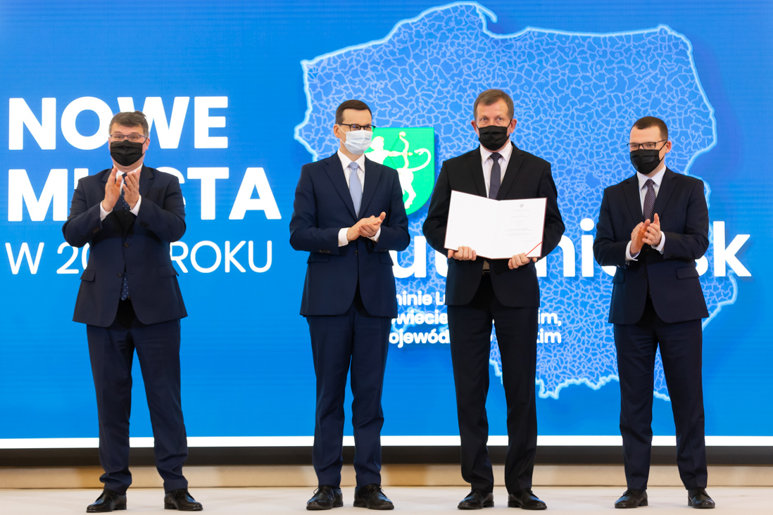 Na zdjęciu widać pozujących do zdjęć premiera Mateusza Morawieckiego, wiceministra Macieja Wąsika, Pawła Szefernakera i przedstawiciela jednej z gmin która otrzymała statut miasta.