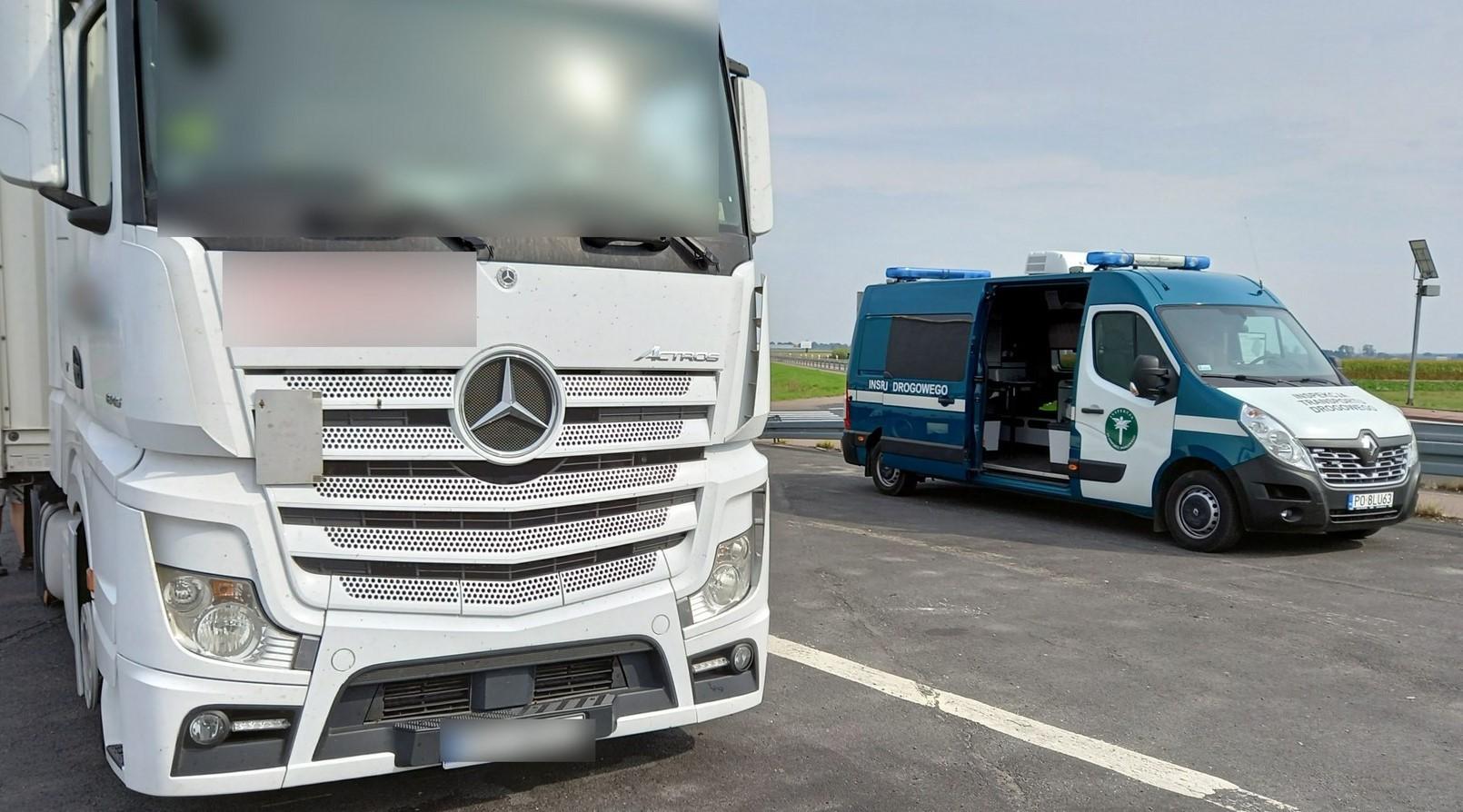 Po lewej stronie widać kabinę kontrolowanej ciężarówki, a po prawej stoi radiowóz ITD z otwartymi drzwiami bocznymi.