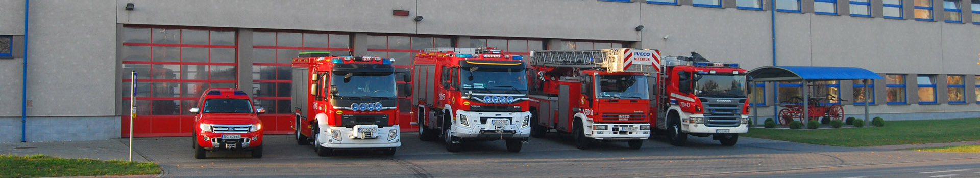 Baner - Szkolna Jednostka Ratowniczo-Gaśnicza - samochody pożarnicze na tle bram wyjazdowych Szkolnej JRG