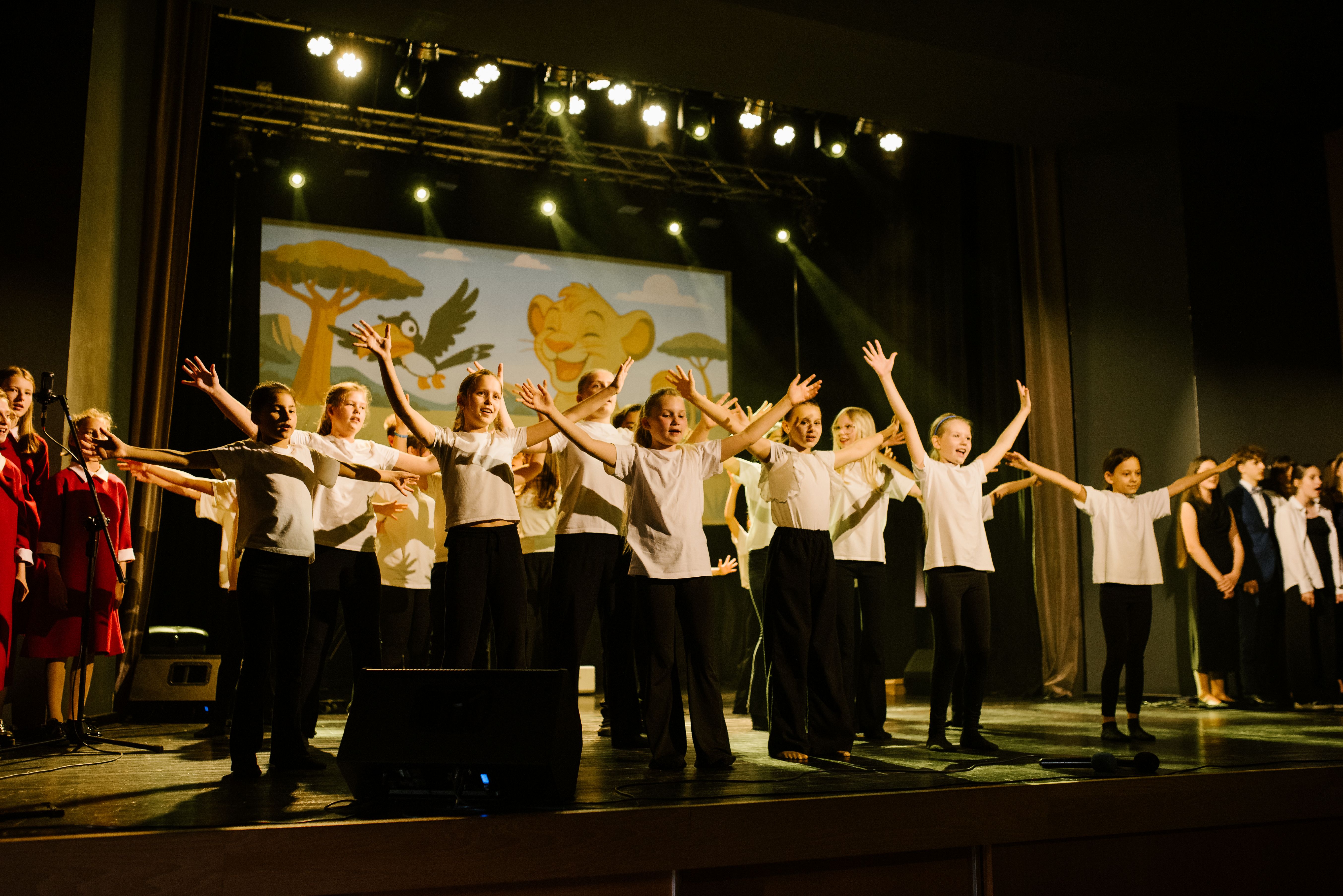 Na zdjęciu widoczna jest duża grupa dzieci wykonujących choreografię taneczną.