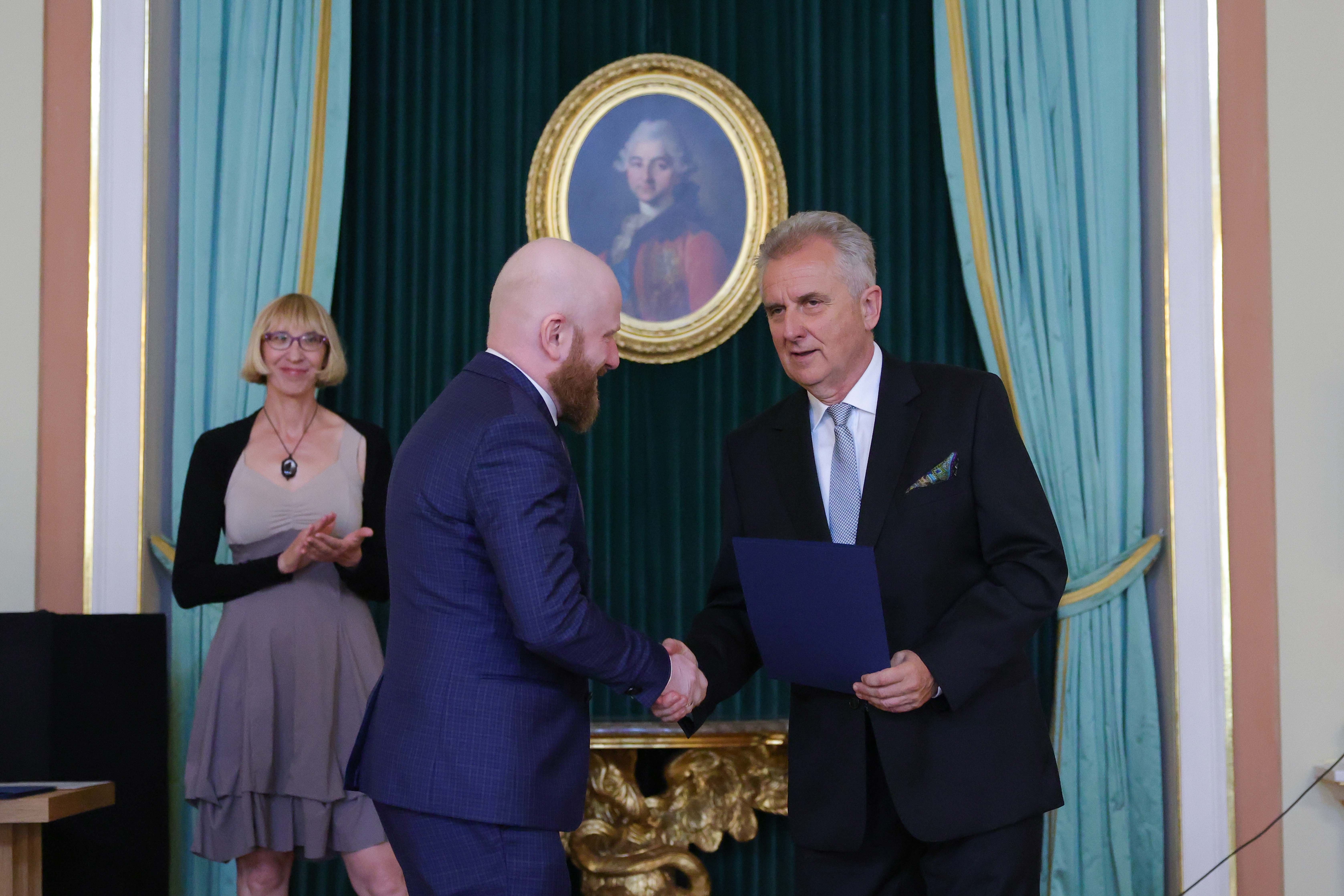 od lewej Pan dr Michał Niżyński przyjmuje akt powierzenia z rąk Podsekretarza Stanu MKiDN