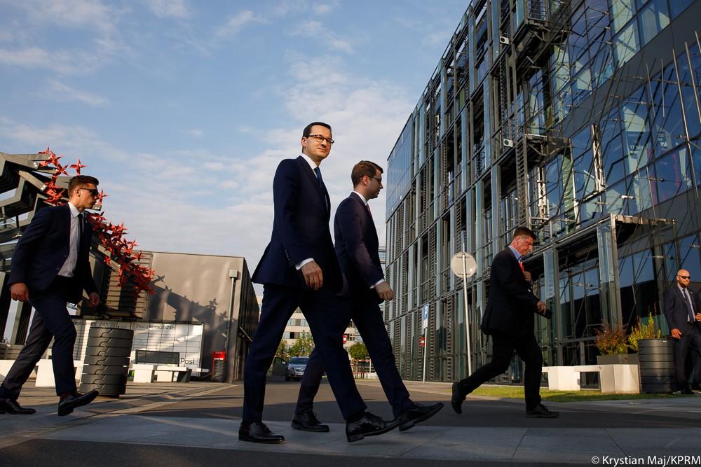 Premier Mateusz Morawiecki oraz minister Piotr Muller idą. 