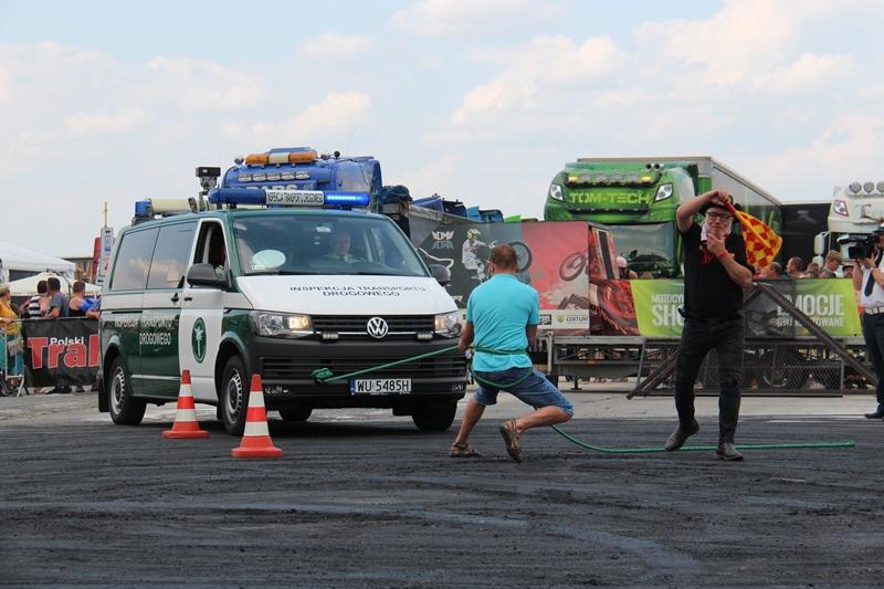 Mężczyzna ciągnie radiowóz na linie