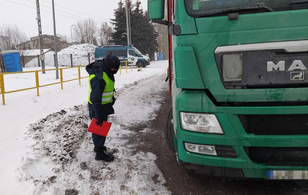 Inspektor kontroluje stan techniczny ciężarówki.