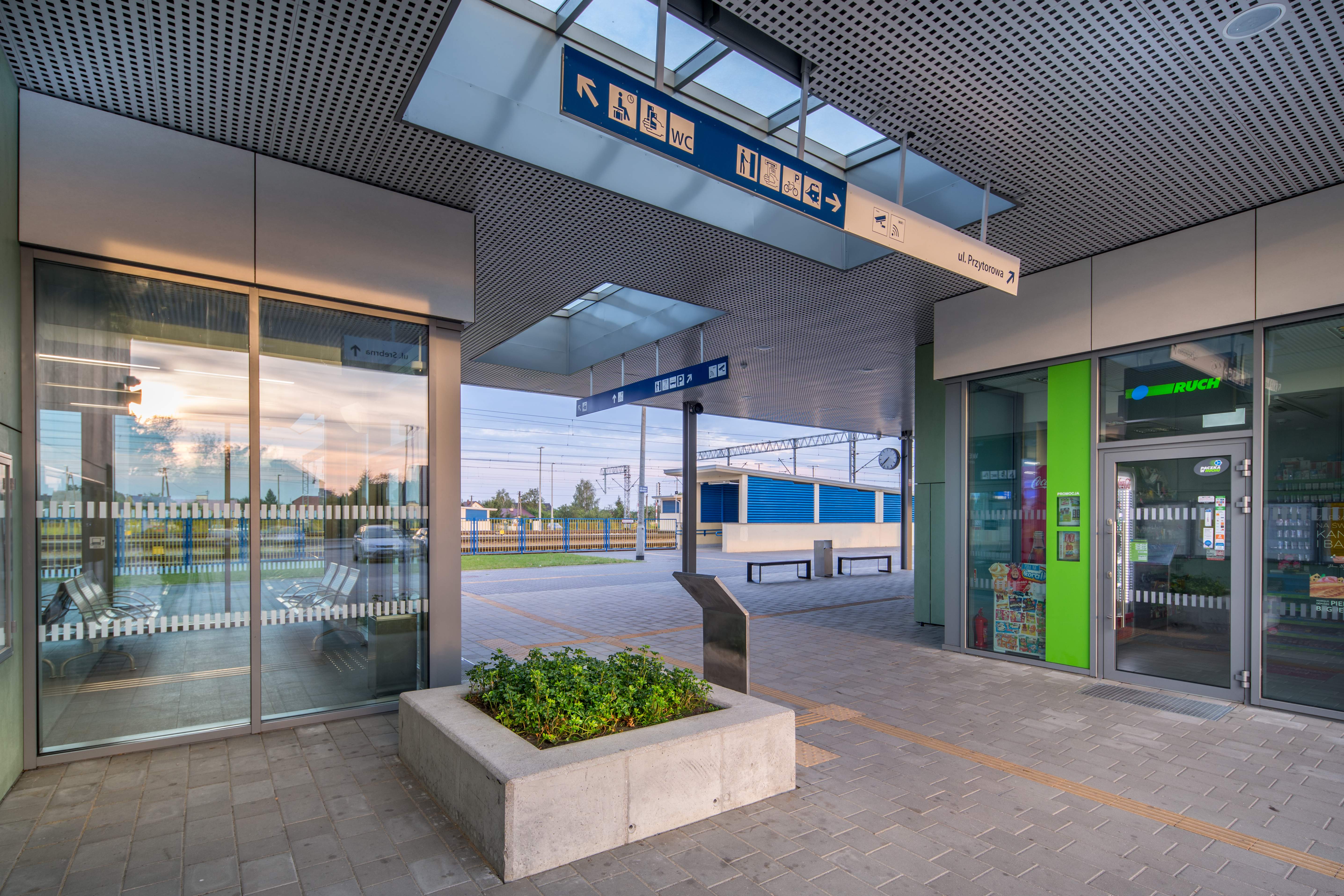 Widok dworca w Nasielsku. Widać wyremontowany budynek. Po prawo kiosk Ruchu. Po lewo poczekalnia dla podróznych. W tle perony.