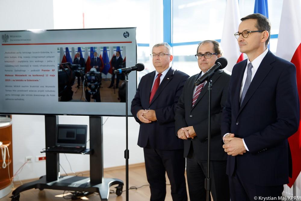 Od lewej: minister Andrzej Adamczyk, minister Marek Gróbarczyk, premier Mateusz Morawiecki stoją podczas konferencji.