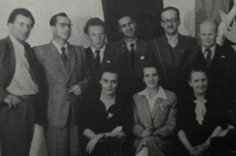 Czarnobiałe zdjęcie nauczycieli szkoły z roku 1950. Sześciu mężczyzn w garniturach stoi a przed nimi siedzą trzy panie. Od lewej stoją: dyrektor Franciszek Bachniak, Łojewski (kom. rodz.), redaktor, naucz: Henryk Burzyński, Goździuk Jan, NN. Siedzą od lewej: Maria Bachniak, M. Łojewska (kom. rodz.), naucz. Helena Niewieska.