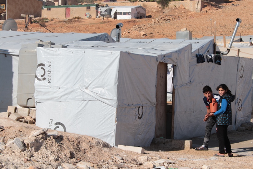 Dwójka dzieci myje ręce przed namiotem w obozie w Libanie