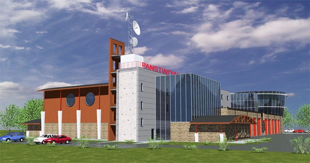 Wizualizacja obiektu nowej strażnicy KM PSP Nowy Sącz. Widok od strony wspinalni oraz sali gimnastycznej. Widać część placu zewnętrznego oraz na dalszym planie rotundę.