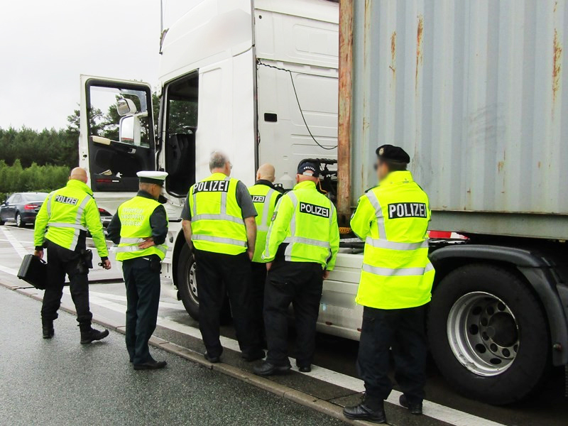Zespół pojazdów zatrzymany do kontroli. Na zdjęciu ciężarówka. Koło niej 5 funkcjonariuszy niemieckiej Policji i inspektor Inspekcji Transportu Drogowego.