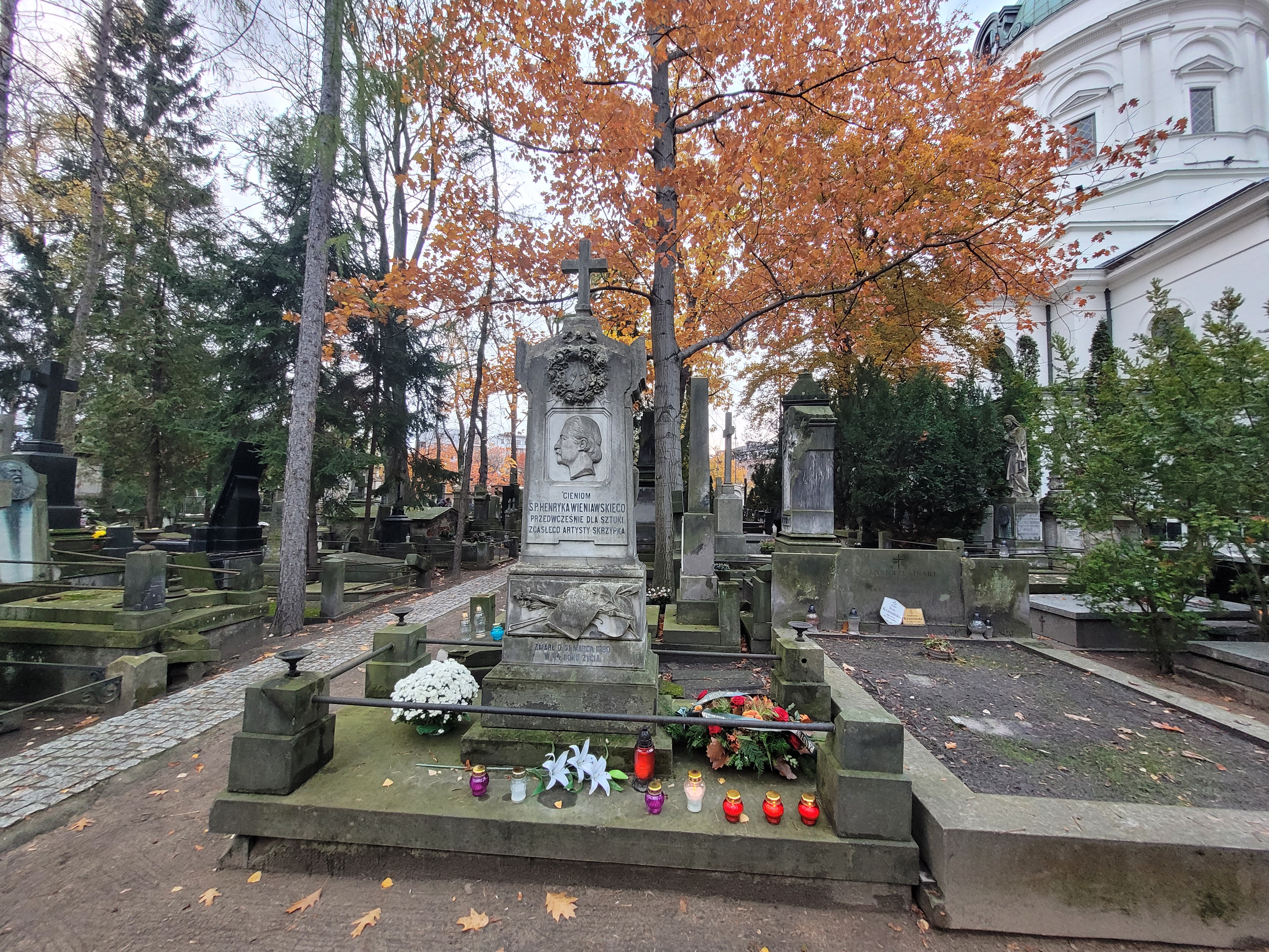 Zdjęcie grobu Henryka Wieniawskiego na cmentarzu Powązkowskim w Warszawie, na grobie złożono wiązankę kwiatów.