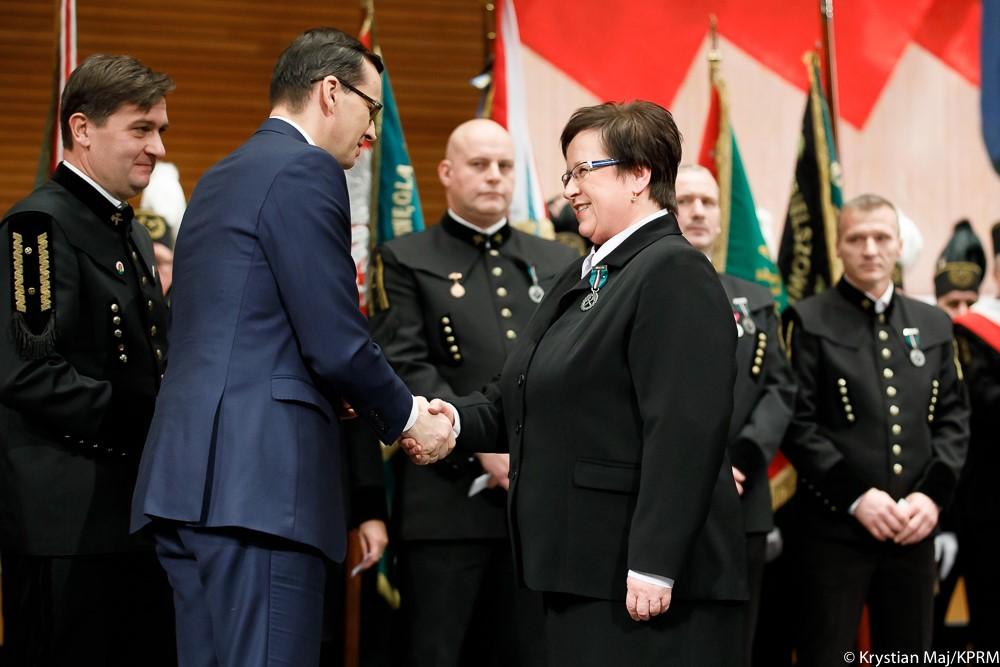 Premier Mateusz Morawiecki gratuluje kobiecie, która otrzymała medal.