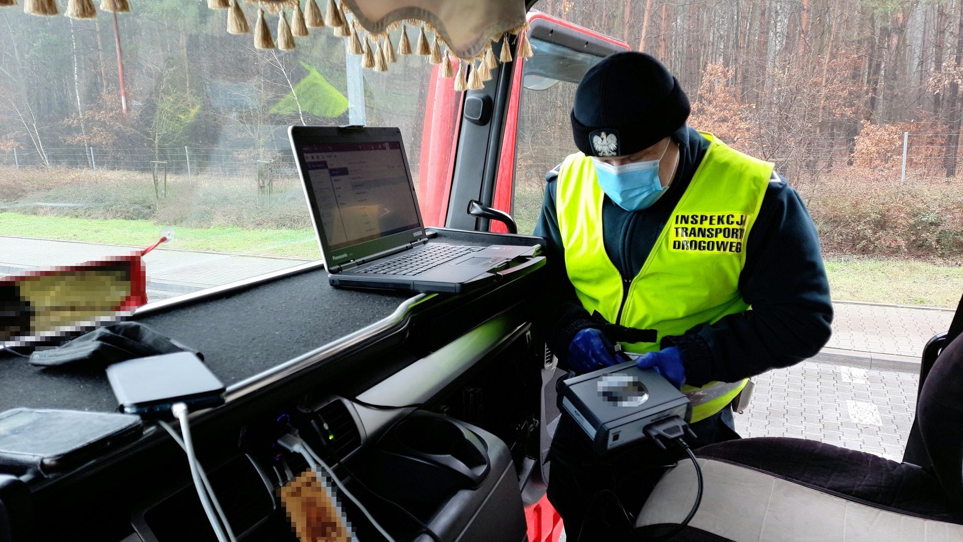 Inspektor w kabinie ciężarówki kontroluje przy pomocy urządzenia diagnostycznego