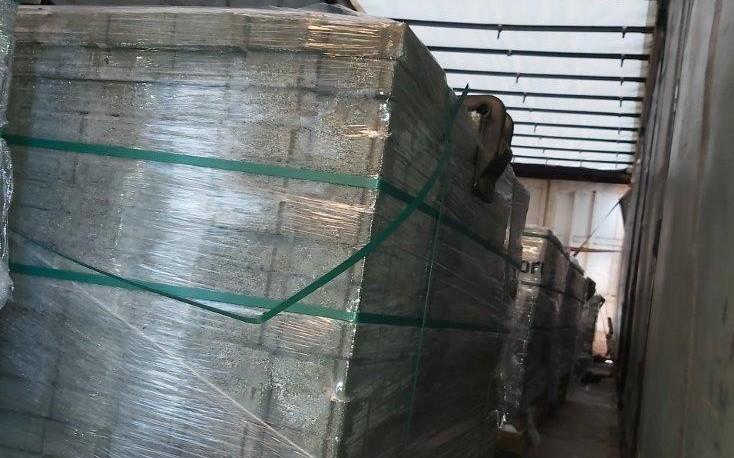 Niezabezpieczony ładunek kostki brukowej na kontrolowanej naczepie.