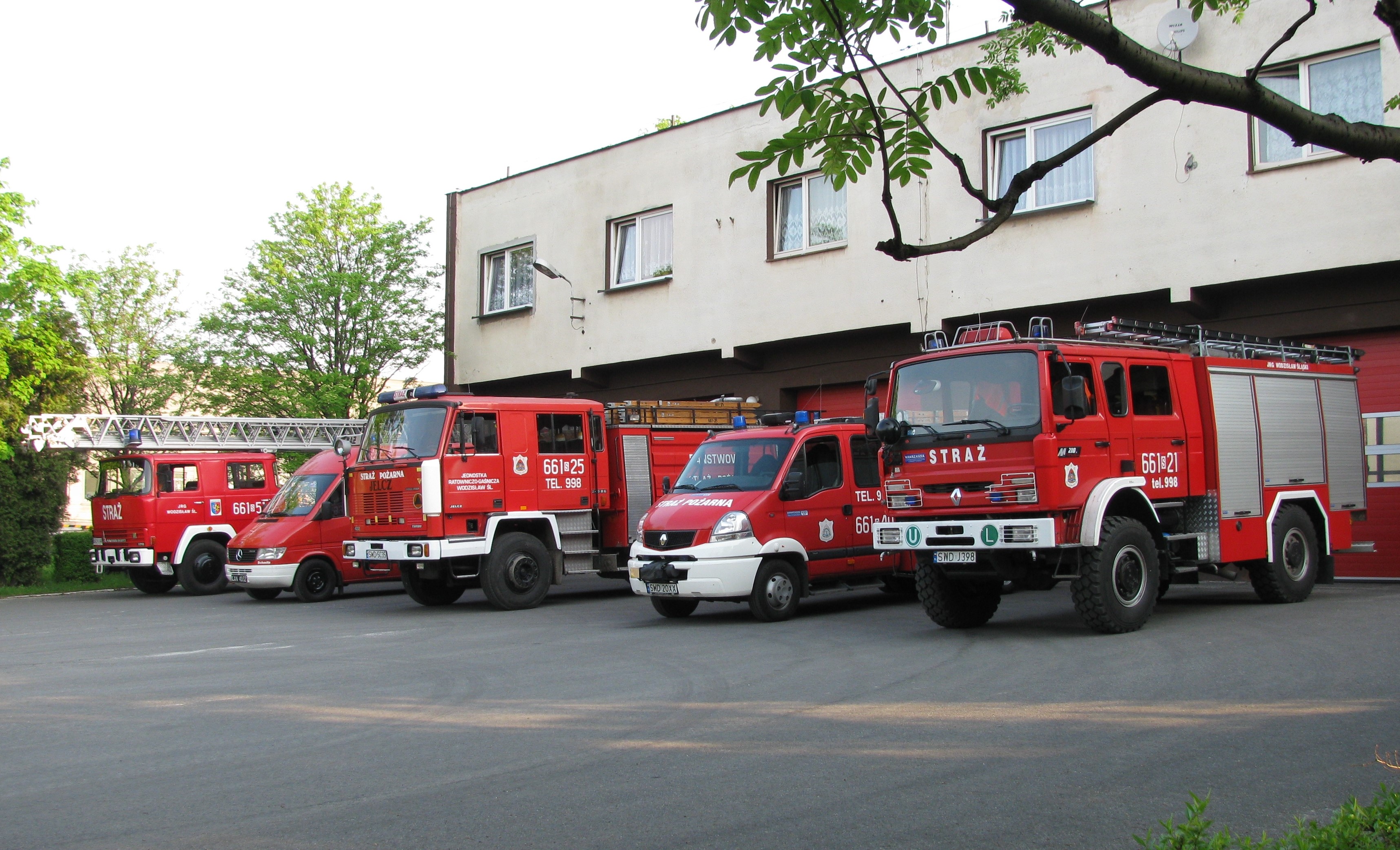Na zdjęciu 5 samochodów pożarniczych na tle budynku Komendy Powiatowej PSP
