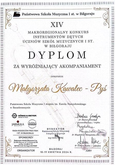 Na białym tle cień trąbki. Wokoło Złoty pasek. Napis Państwowa Szkoła Muzyczna I st. w Biłgoraju XIV Makroregionalny Konkurs Instrumentów Dętych Uczniów Szkół Muzycznych I st. w Biłgoraju, Dyplom za wyróżniający akompaniament otrzymuje Małgorzata Kawalec - Pyś. Państwowa Szkoła Muzyczna I stopnia im. Karola Namysłowskiego w Szczebrzeszynie, nauczyciel - Józef Tokarz. Pod spodem pieczęć szkoły Muzycznej, loga sponsorów i podpisy komisji. 