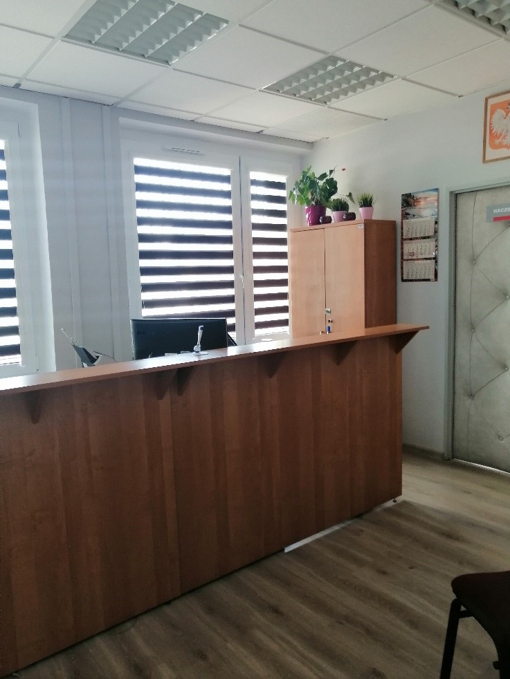 Wnętrze sali obsługi - wysoka lada, z tyłu okna przesłonięte żaluzjami typu dzień/noc