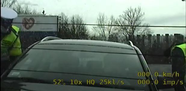 Funkcjonariusze ITD stoją przy zatrzymanym samochodzie osobowym
