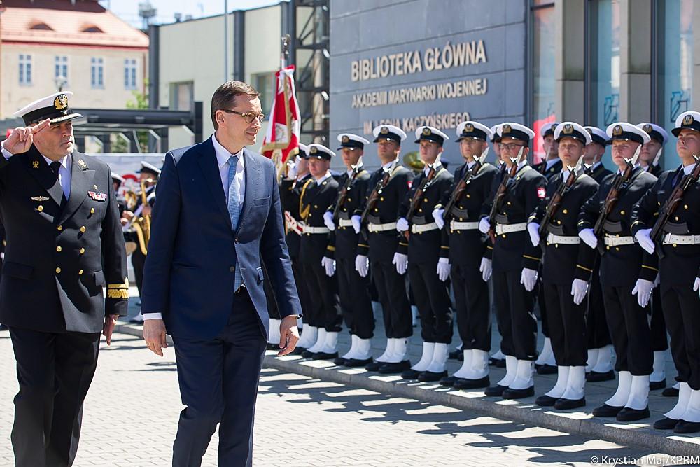 Premier Mateusz Morawiecki idzie wzdłuż szpaleru.