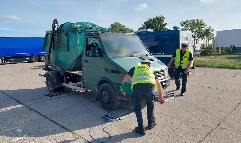 Inspektorzy ważą pojazd przewożący odpady na wysypisko śmieci.