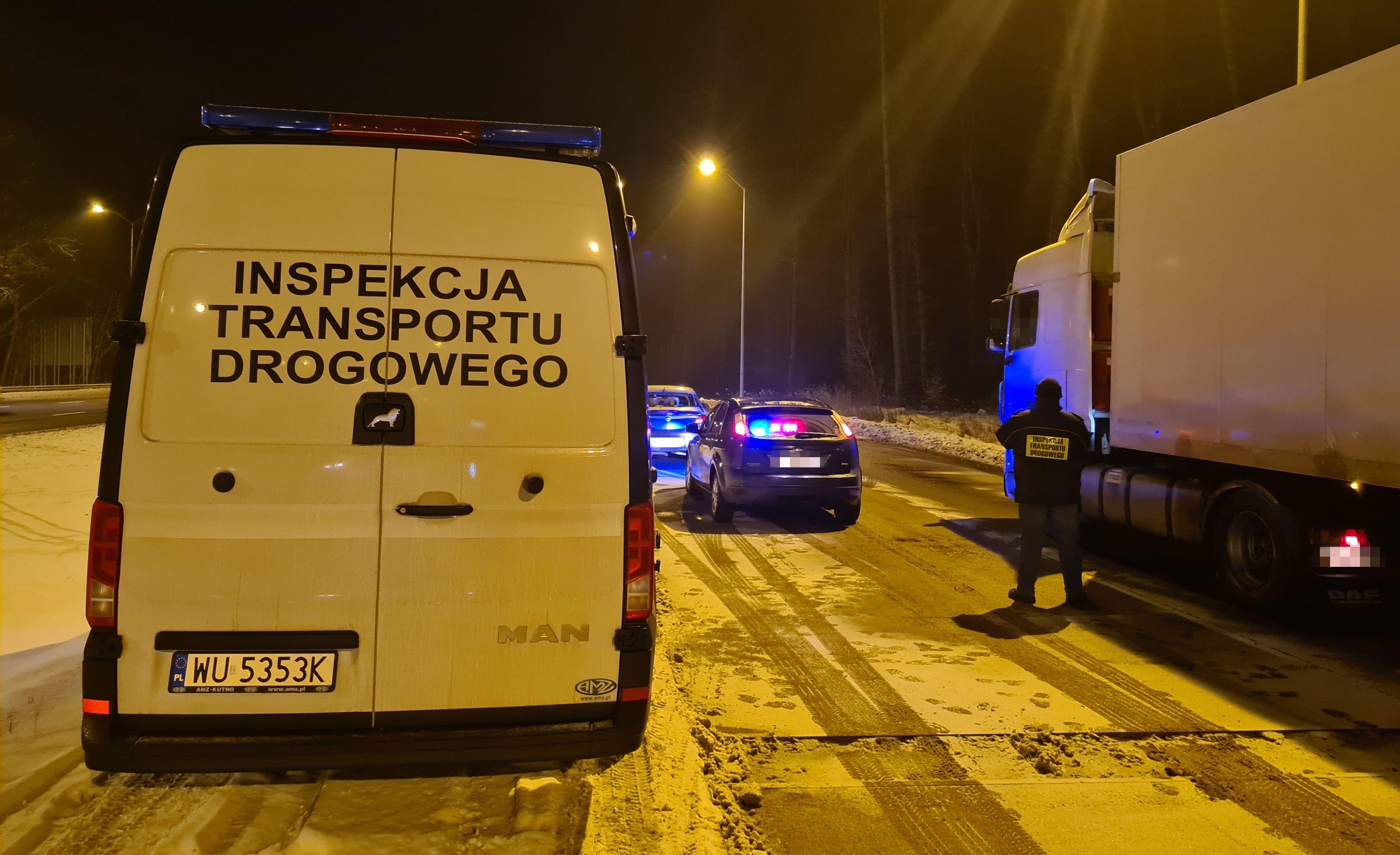 Radiowóz ITD, inspektor i kontrolowana w nocy ciężarówka.