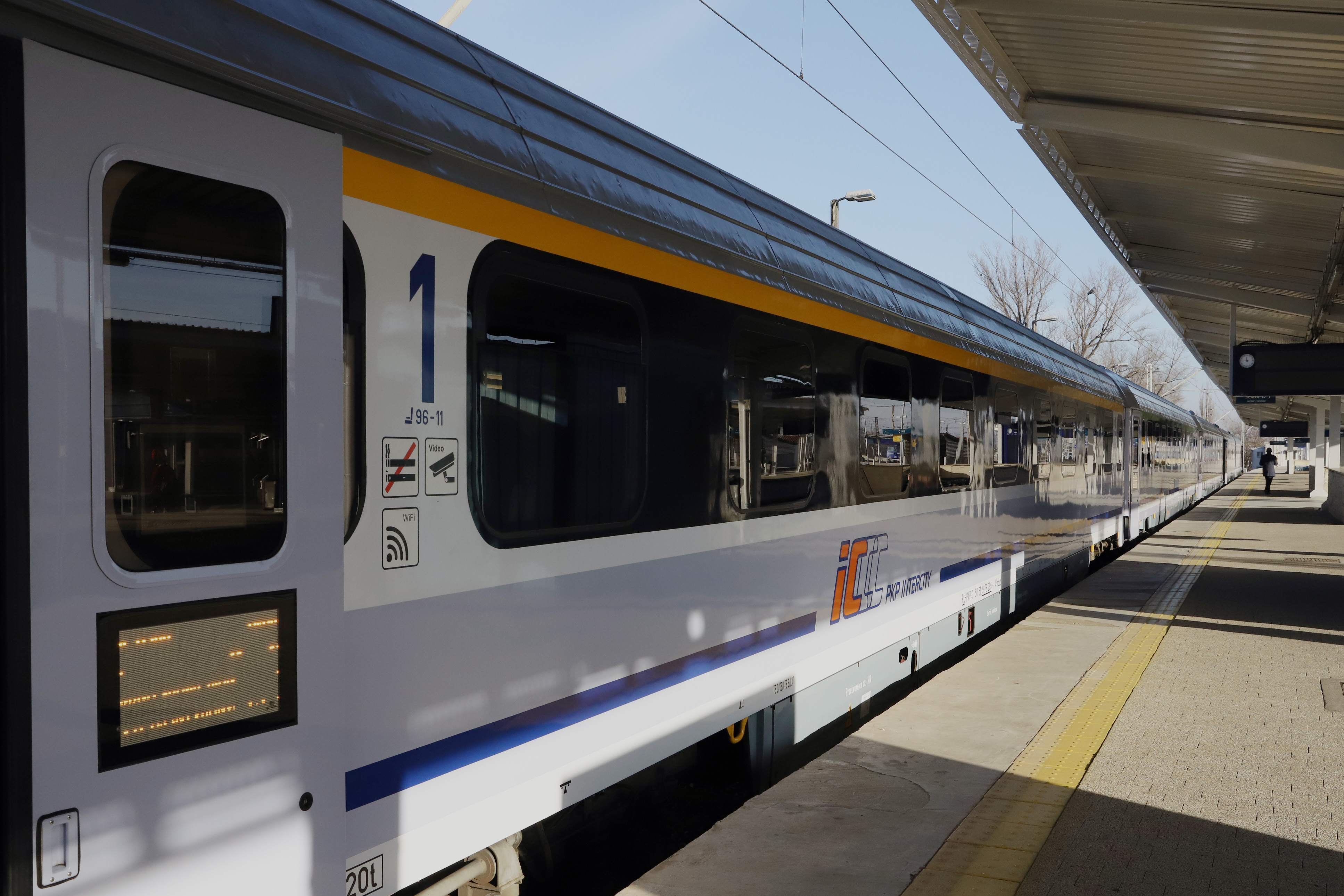 Na zdjęciu widać wagon pociągu, który stoi przy peronie. 