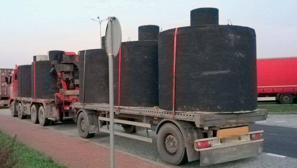 Mocno przeładowana ciężarówka z szambami.