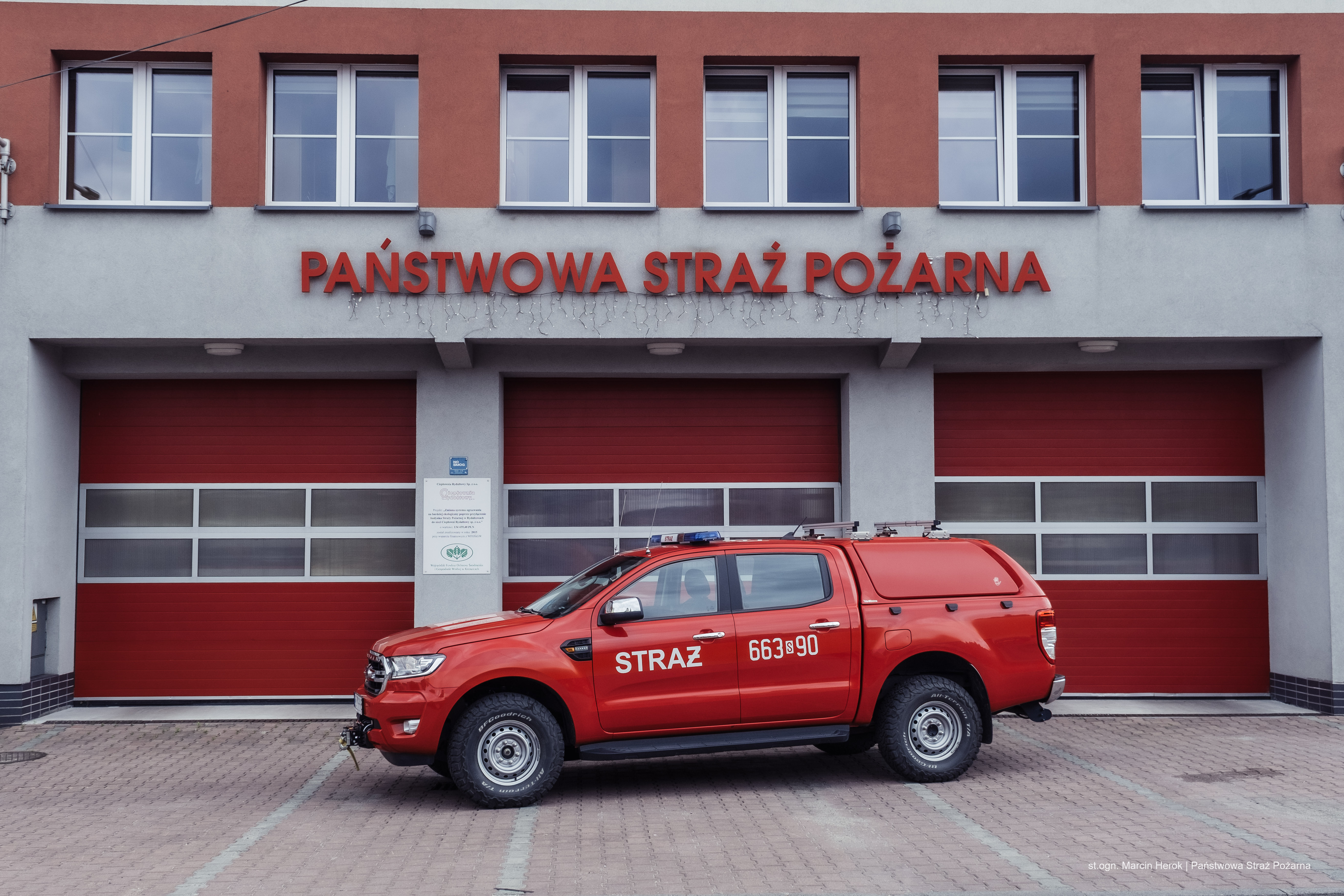 Zdjęcie przedstawia lekki samochód rozpoznania ratowniczego. W tle budynek Jednostki Ratowniczo-Gaśniczej w Rydułtowach.
