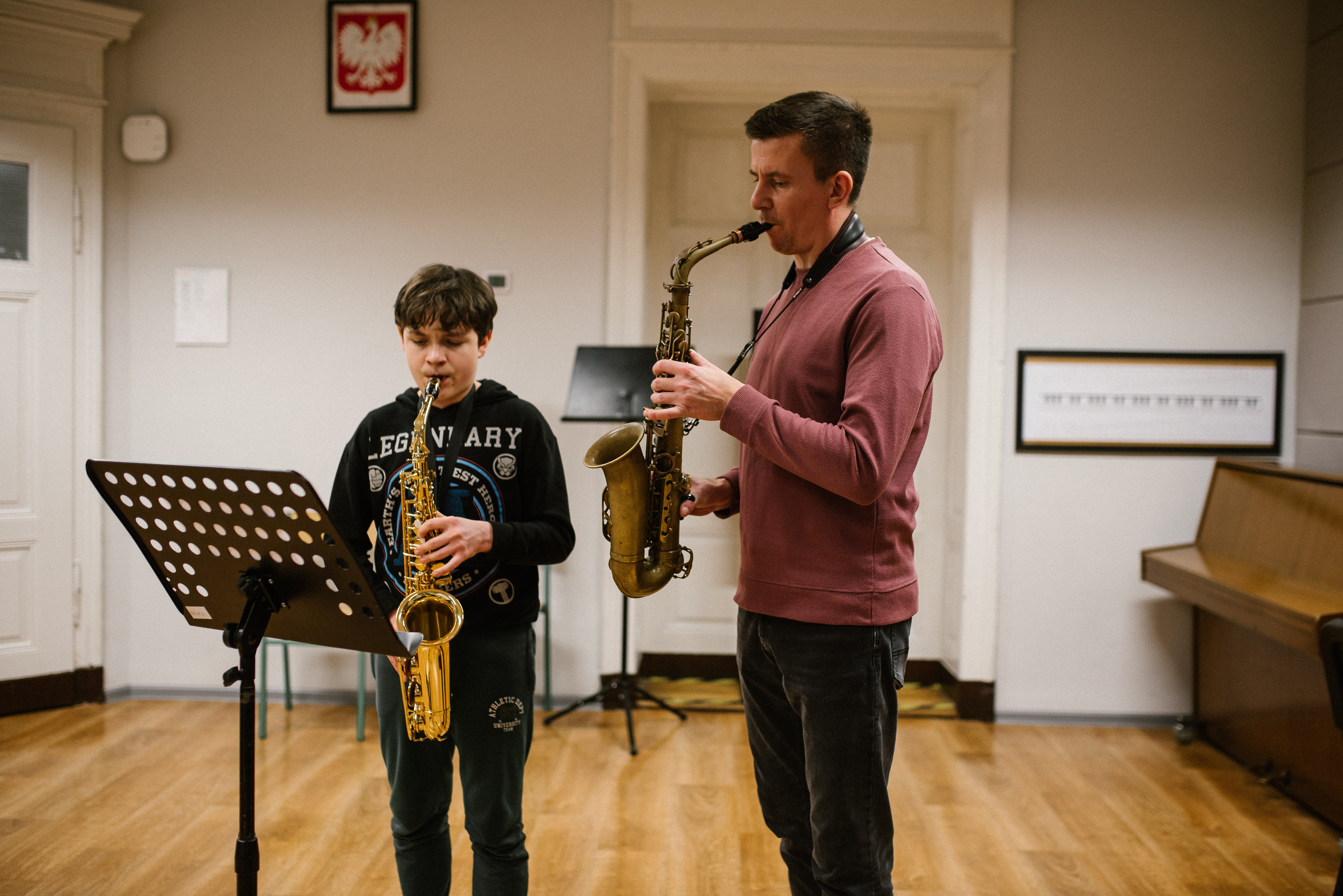 Na zdjęciu widoczny jest nauczyciel gry na saksofonie oraz uczeń.