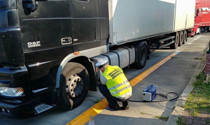 Inspektor przy ciężarówce kontroluje przy pomocy dymomierza spaliny