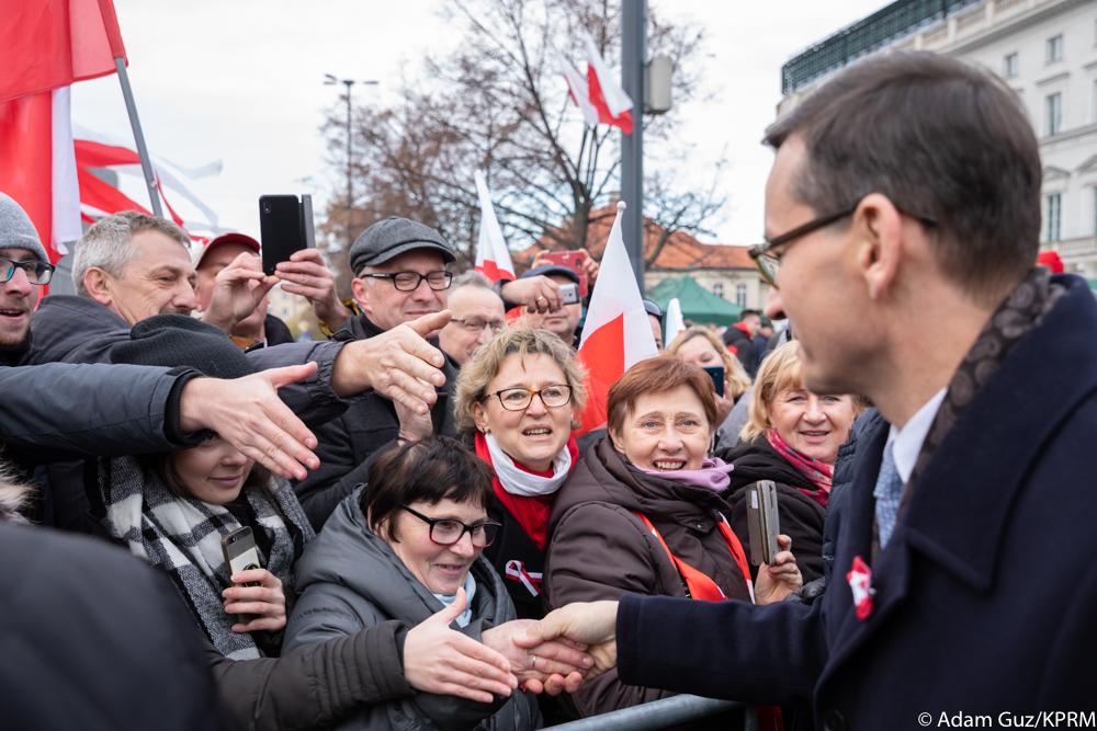 Premier Mateusz Morawiecki ściska dłonie mieszkańcom.