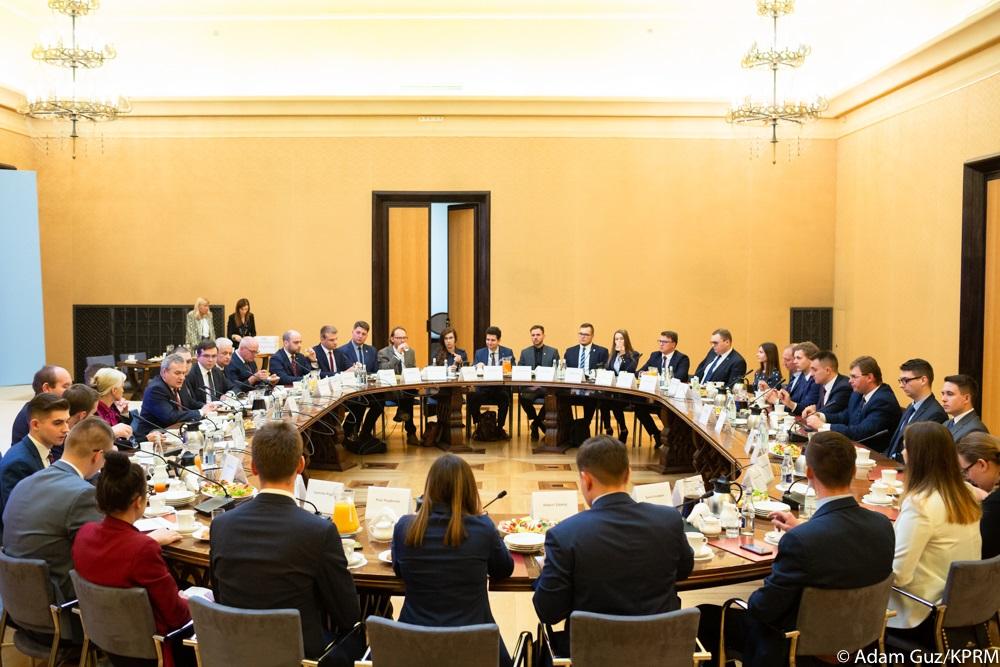 Przedstawiciele młodych siedzą przy okrągłym stole.