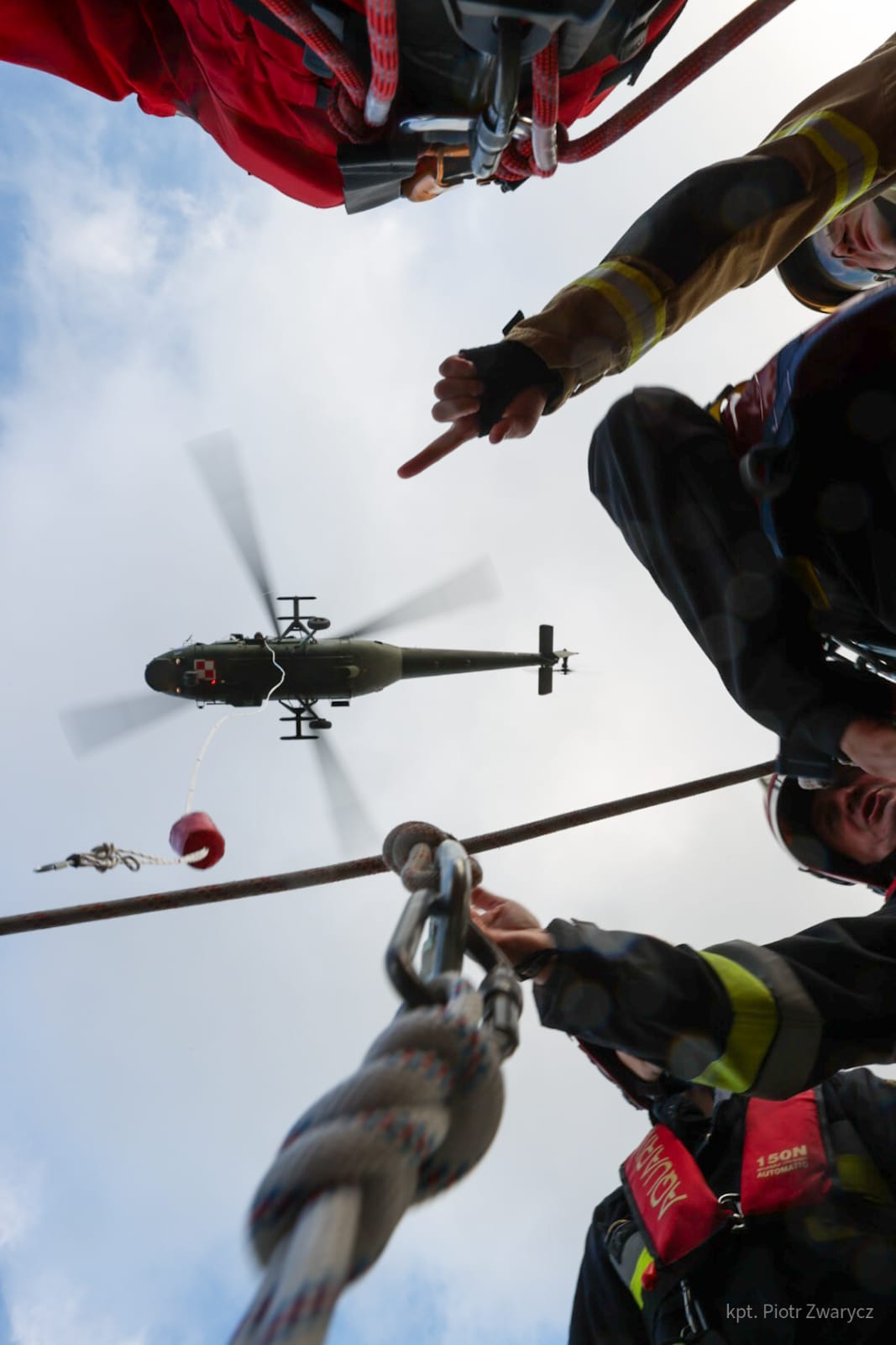 Helikopter w powietrzu. Widok z dołu z perspektywy ratowników będących na ziemii