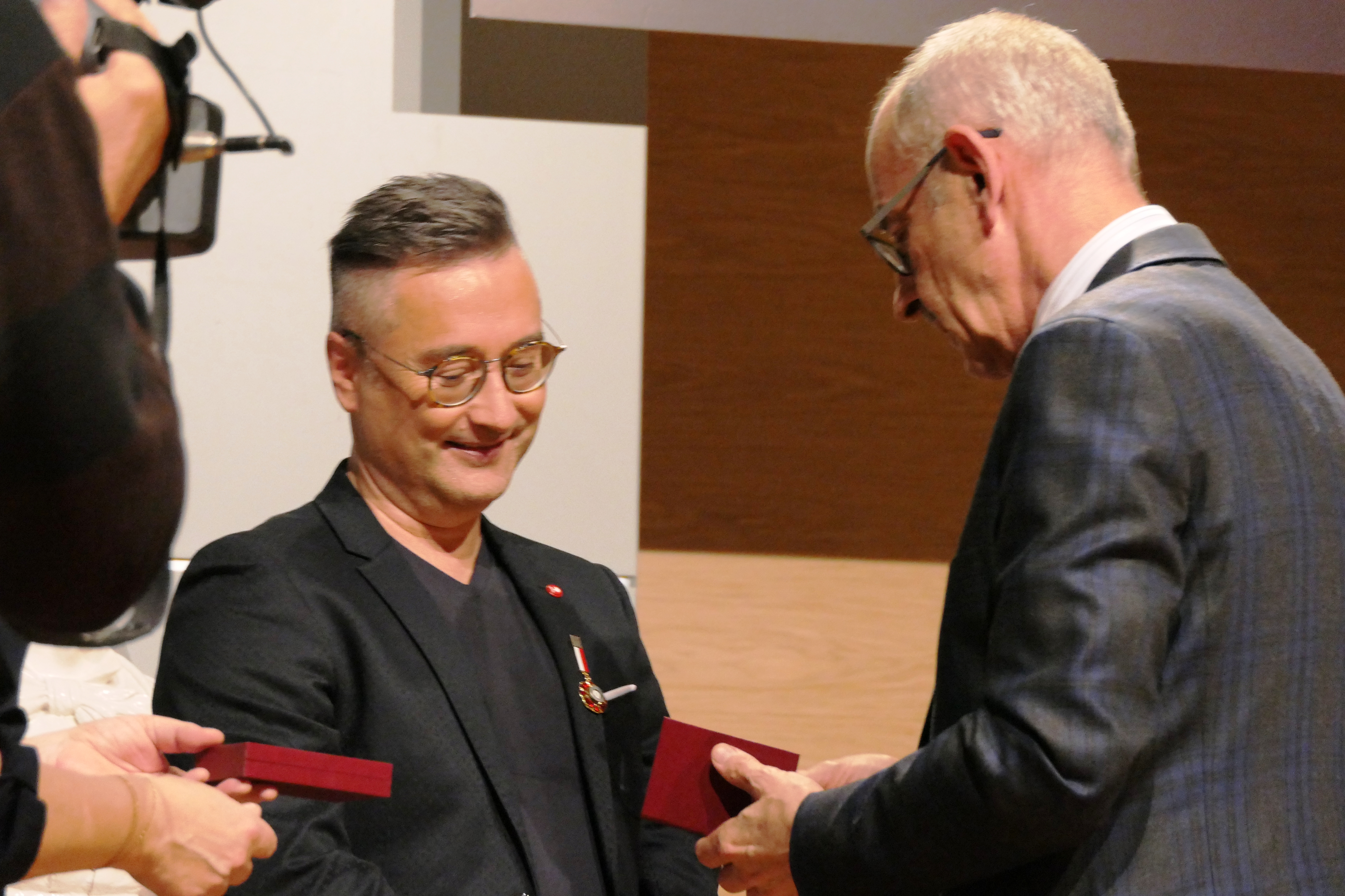 Zdjęcie przedstawiające od prawej Wizytatora CEA Zenobiusza Kajdę wręczającego odznakę honorową „Zasłużony dla kultury polskiej” doktorowi habilitowanemu Jackowi Ściborowi stojącego stojącego po lewej stronie.