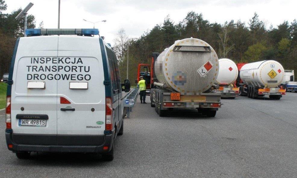 Radiowóz oznakowany ITD i kontrolowane ciężarówki przewożące towary niebezpieczne.