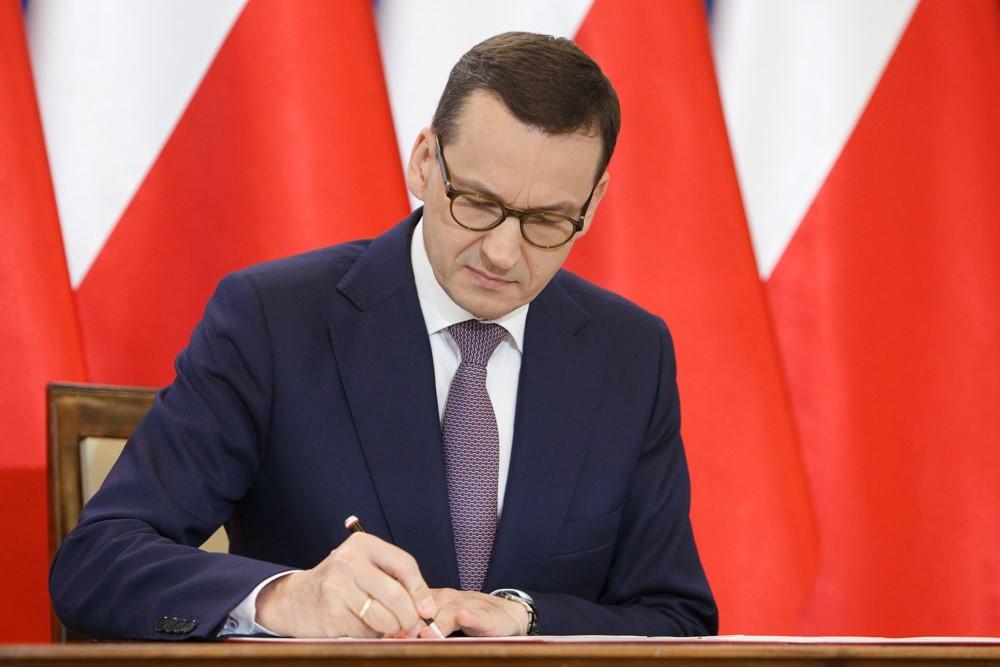 Premier Mateusz Morawiecki podpisuje deklarację.