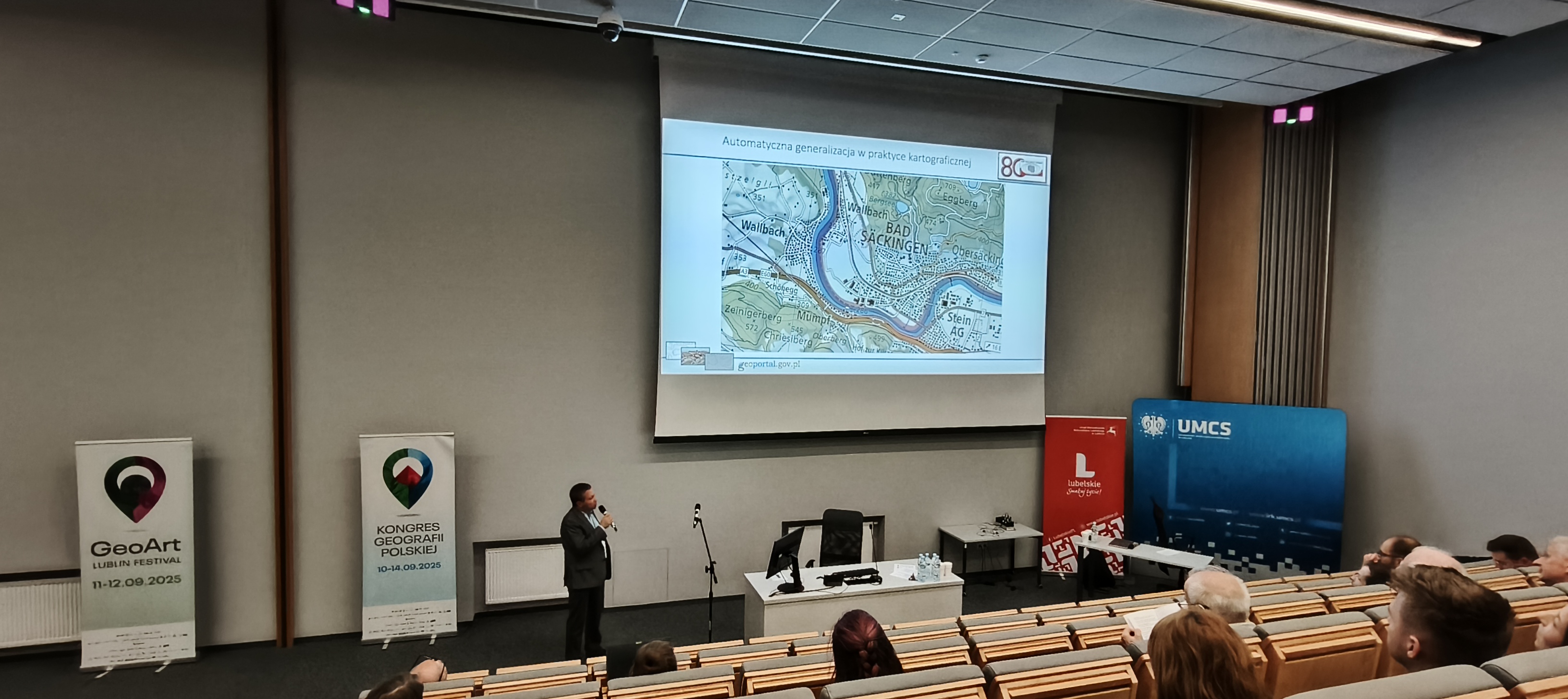 Ilustracja przedstawia przedstawiciela GUGiK podczas prezentacji