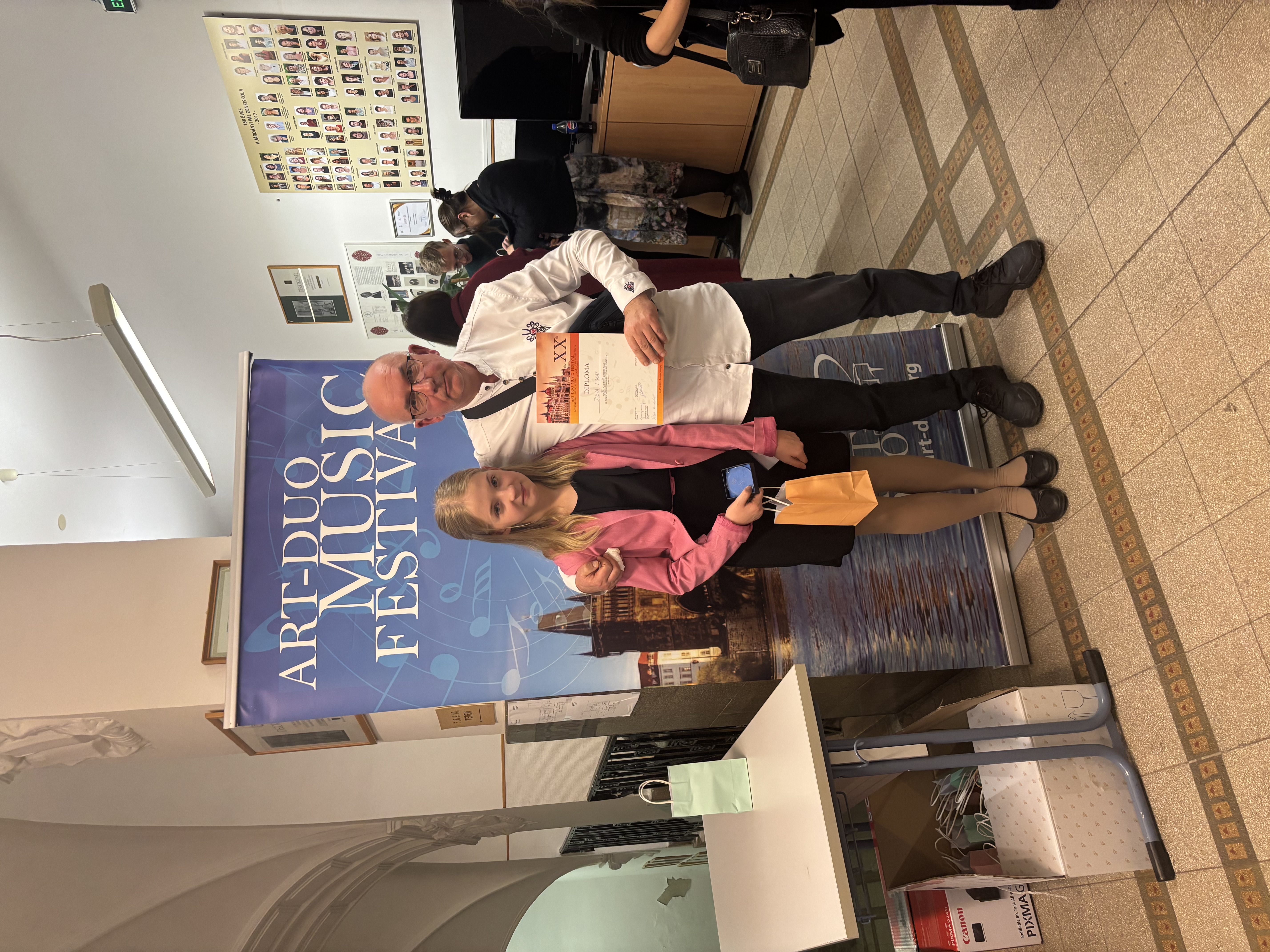 Julia Iskat, Robert_Handermander Art_duo 2025. Uczennica z nauczycielem na tle baneru konkursu