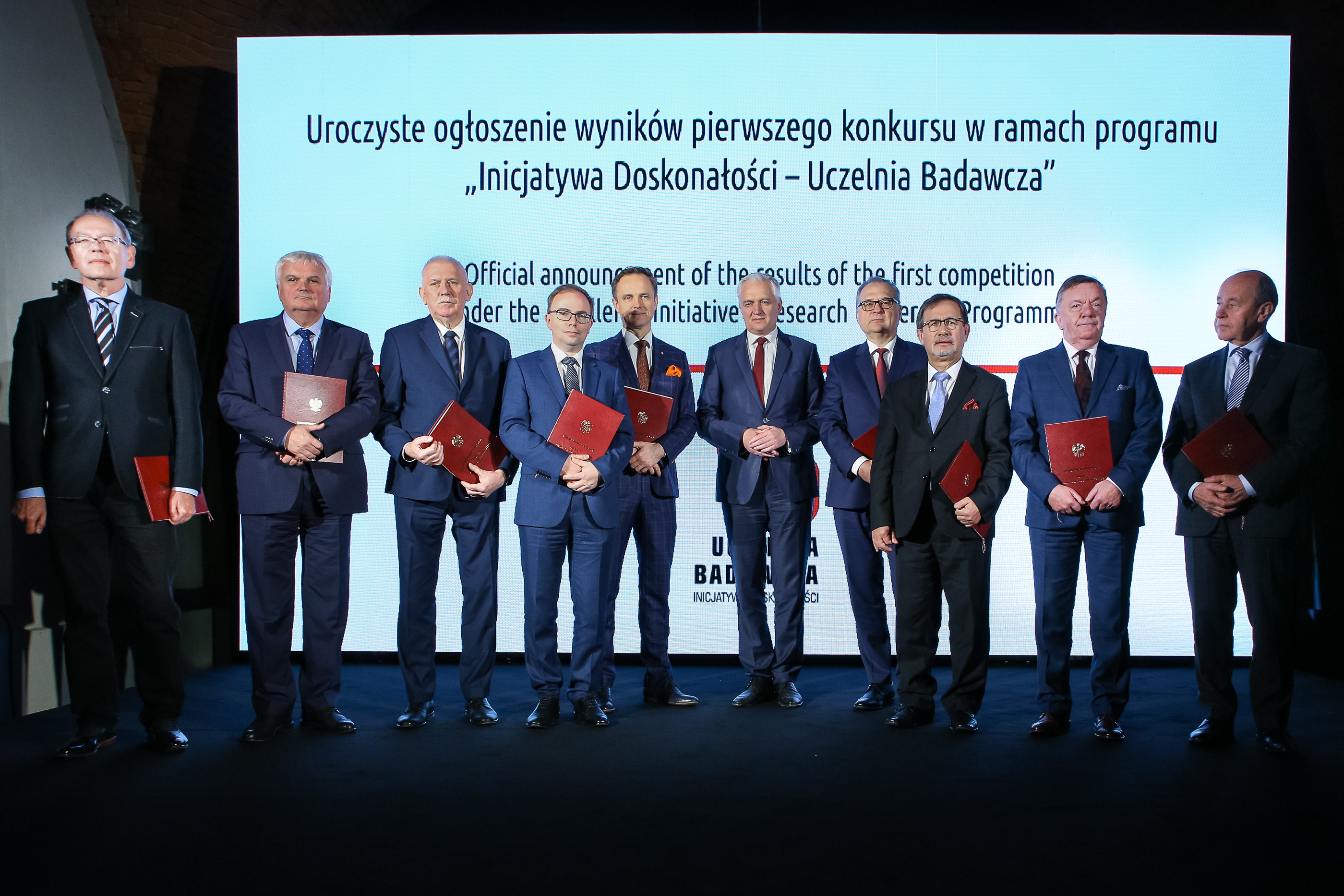 Rektorzy 10 uczelni stoją na scenie z premierem J. Gowinem