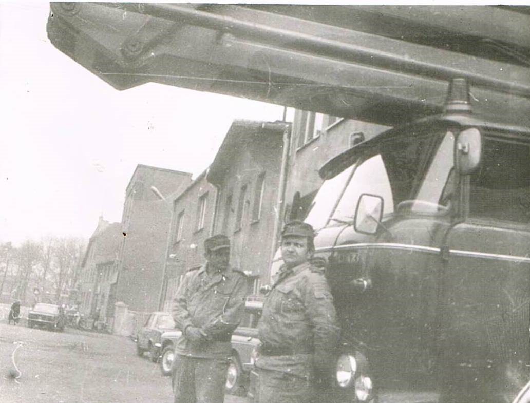 Na zdjęciu dwóch strażaków na tle podnośnika SH20