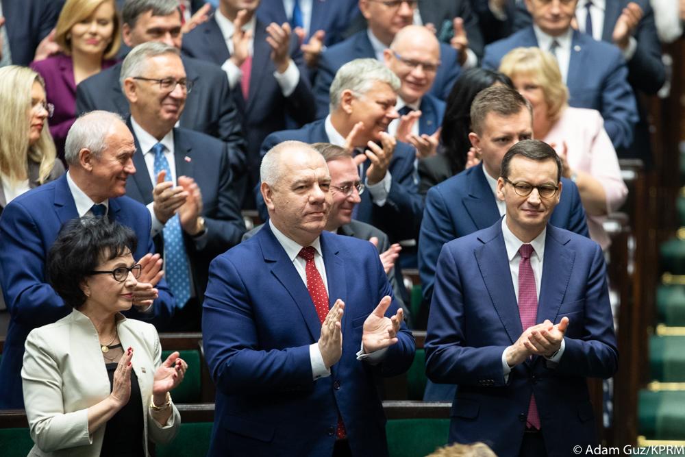 Premier Mateusz Morawiecki i posłowie biją brawo.